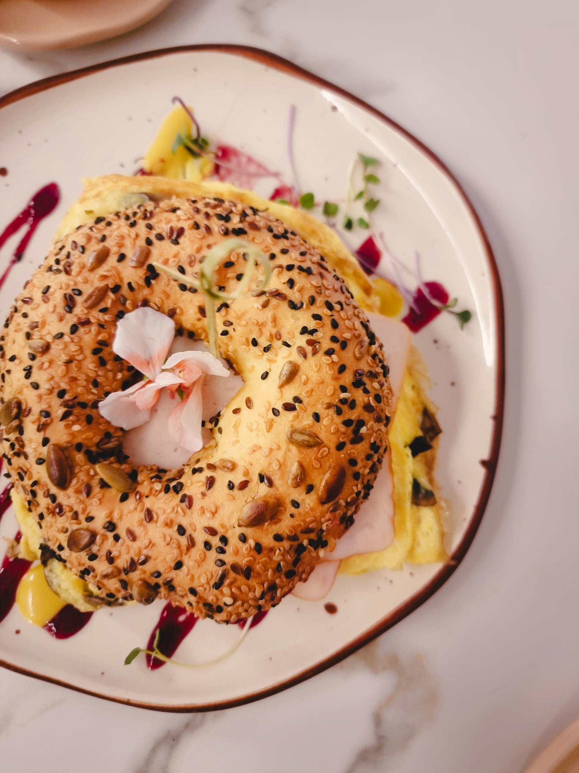 Bagel relleno de jamón, queso y aguacate.