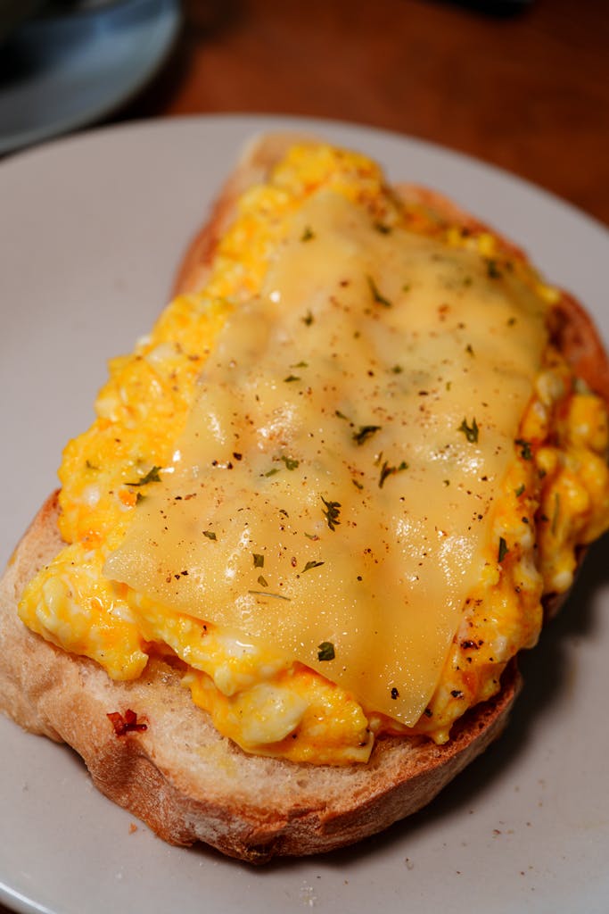 Sándwich caliente de huevo cremoso con queso derretido.