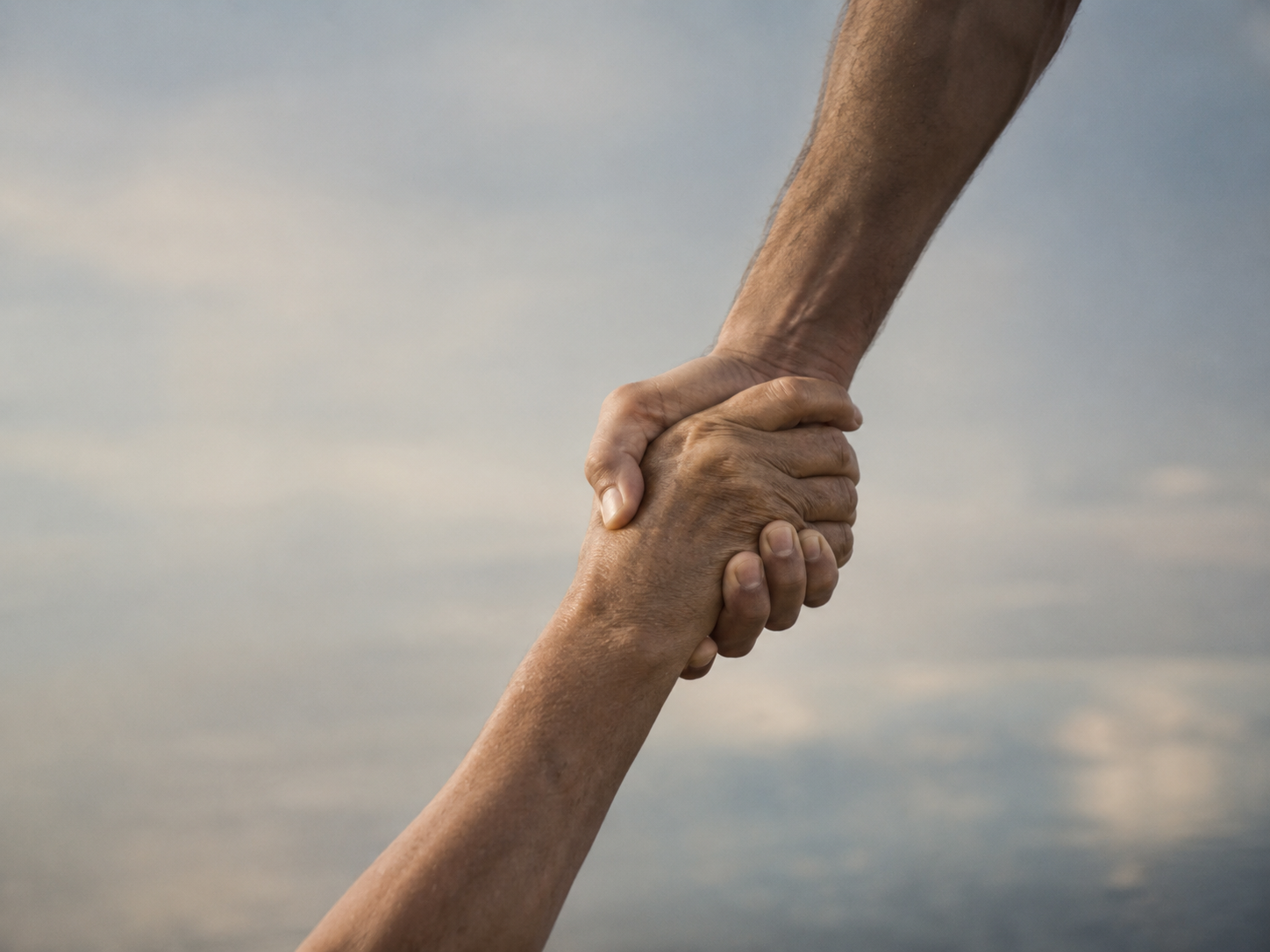 Dos manos se sostienen como símbolo de ayuda, comunidad y resiliencia.