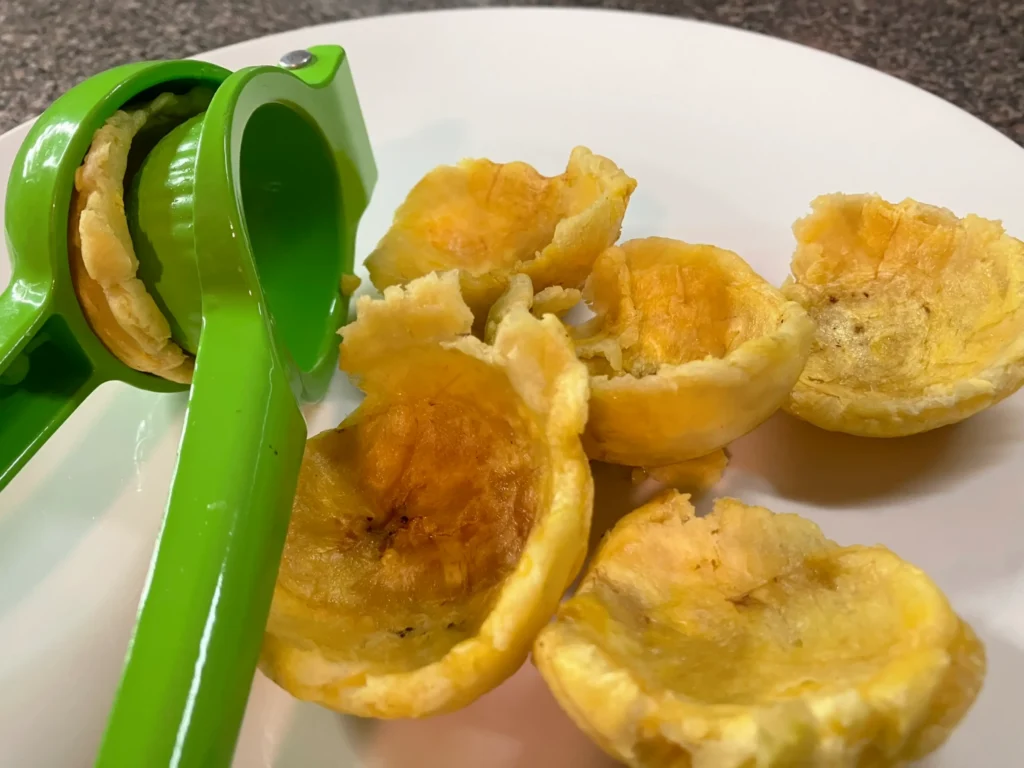 Uso de un exprimidor de limones manual para moldear canastas de tostones de platano macho en CarolinMagazine