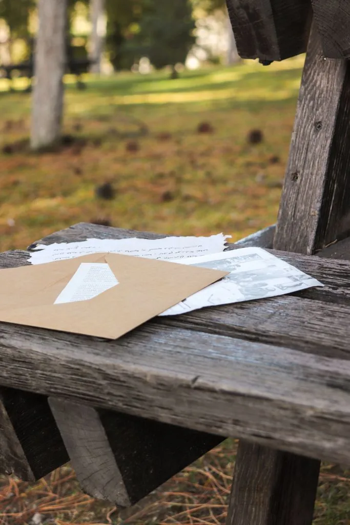 Cartas y sobres sobre una banca de madera al aire libre.